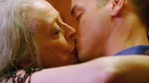 Ung man och äldre kvinna pussas